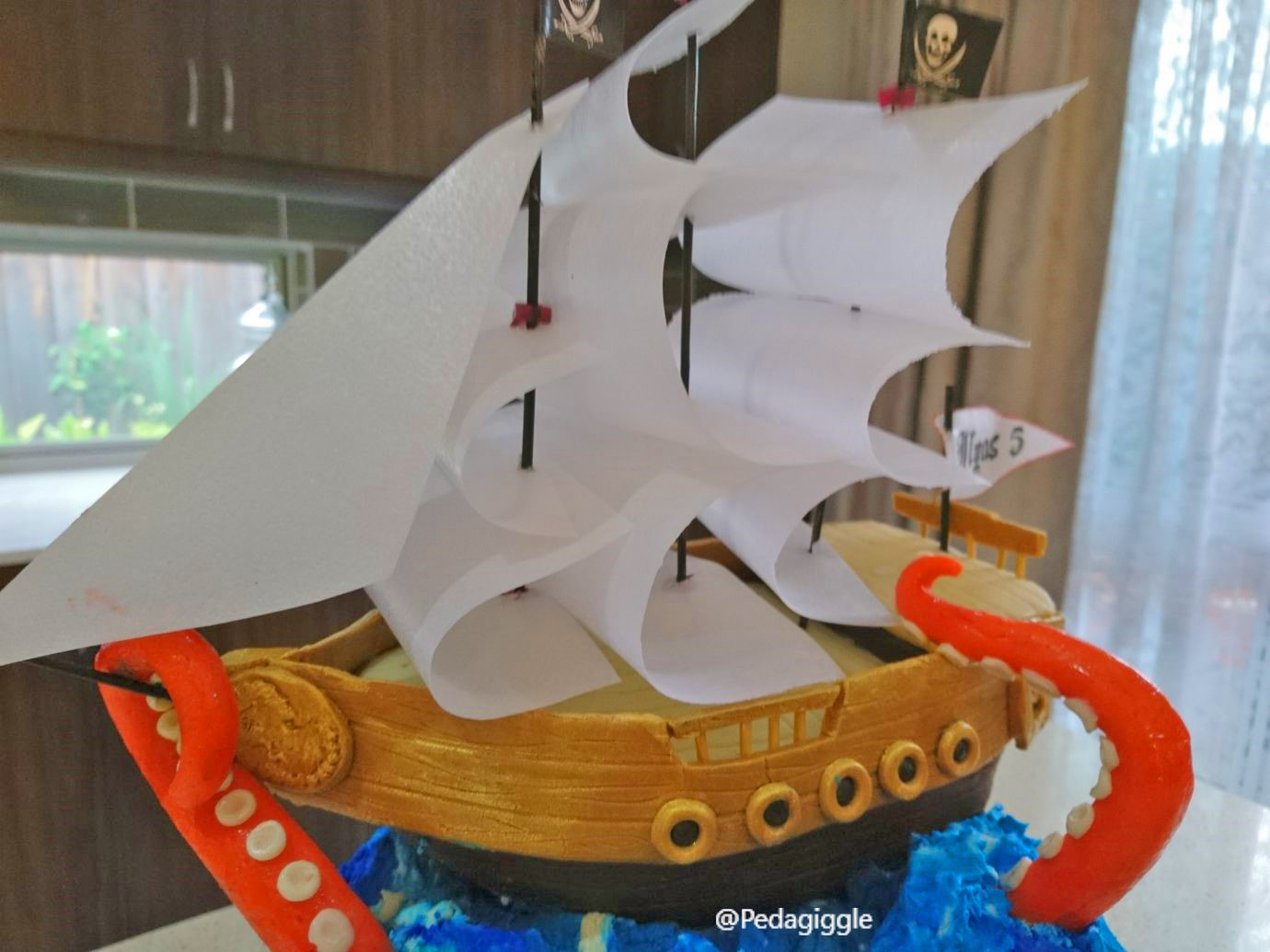 Extravagant pirate ship birthday cake that's being attacked by a giant octopus