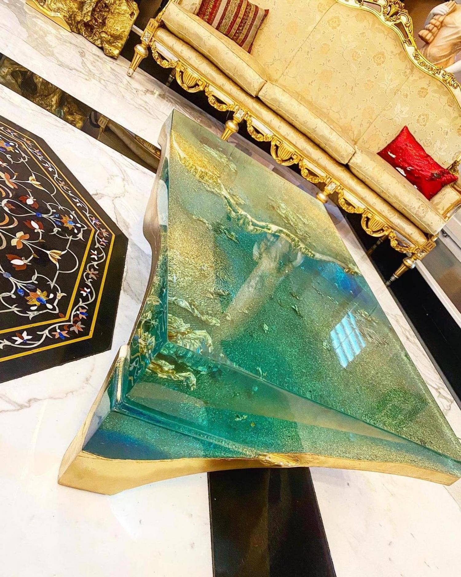 luxury table is a concrete sculpture and filled with epoxy to give stunning illusion of looking into a deep dark blue sea
