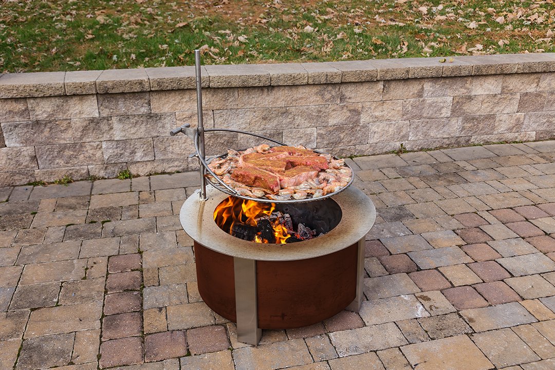  Ultimate Campfire Grill Turns Your Fire Pit Into a Tiered Cooking Machine - Breeo Fire pit cooker with winch